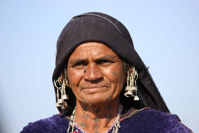 Rabari lady with tattoos on her face and traditional earrings