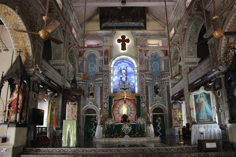 Plush interior of a catholic church, altar lit and baroque architecture.