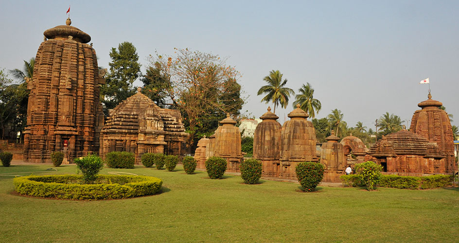 Complex of old brick temples with typical towers and manicured lawns and walks.