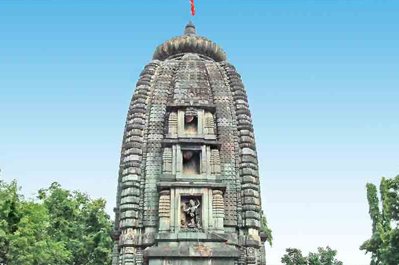 A carved stairway with levels and religious statues of an ancient stone temple tower.