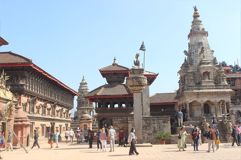 During the Nepal Tour Program, Kathmandu Durbar Square, there are ancient pagoda temples and statues where tourists are walking about the historical place.